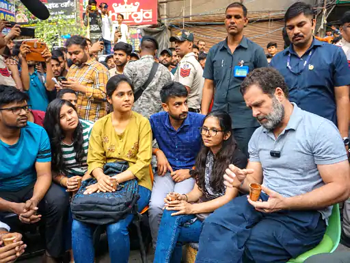 Rahul Gandhi sitting on a roadside chair in Delhi